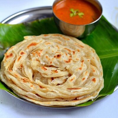 Tandori Chapati kept on banana leaf in a plate with soup.
